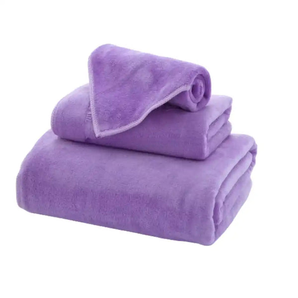 Tres toallas moradas de microfibra para cuerpo, manos y rostro, de la marca Enigma Store, con textura suave y absorbente.