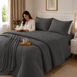Conjunto de cobertor queen de 7 piezas en gris oscuro, con fundas y decoración moderna, ideal para dormitorios elegantes.