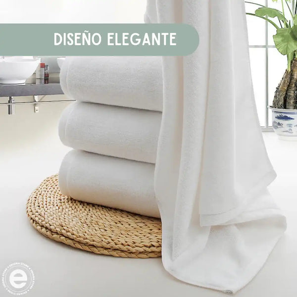 Tres toallas de baño blancas de algodón de 70x140 cm y 500 g, con textura suave y apariencia esponjosa.