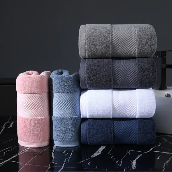 Tres toallas de baño blancas de 70x140 cm y 450g de algodón, de estilo hotel, con textura suave y absorbente.