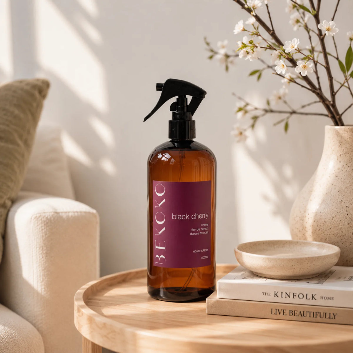 Spray aromatizante de hogar BEKOKO con aroma a cereza negra, muestra el envase en un ambiente decorativo.