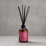 Difusor ambiental BEKOKO con varillas y aroma de dragonfruit y ámbar en frasco de 250ml, en decoración moderna y elegante.